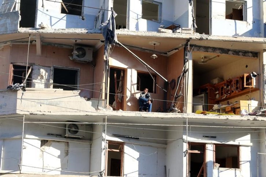 A man sits on the balcony of his damaged house in the rebel-held, besieged al-Sukkari neighborhood of Aleppo.