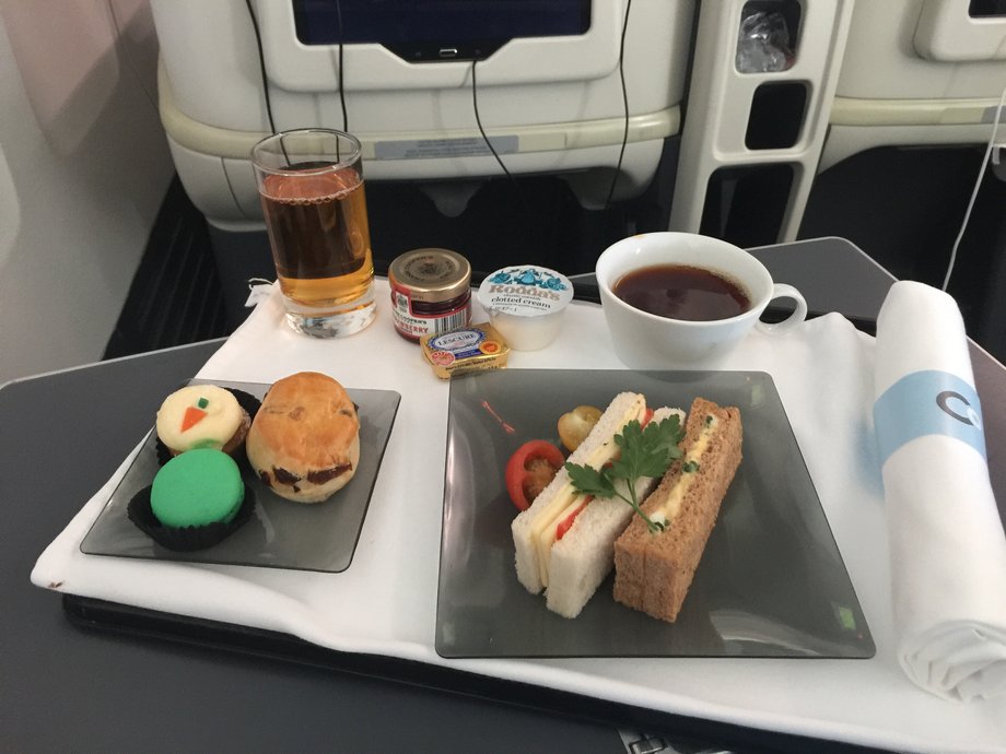 Finally, we were served a course similar to what you'd eat at high tea in London. The flight attendants came around with the "tea and sweets" meal — which included a scone with jam and clotted cream, a macaroon, a miniature carrot cake, two finger sandwiches, juice, and tea — around 9:00 p.m. London time.