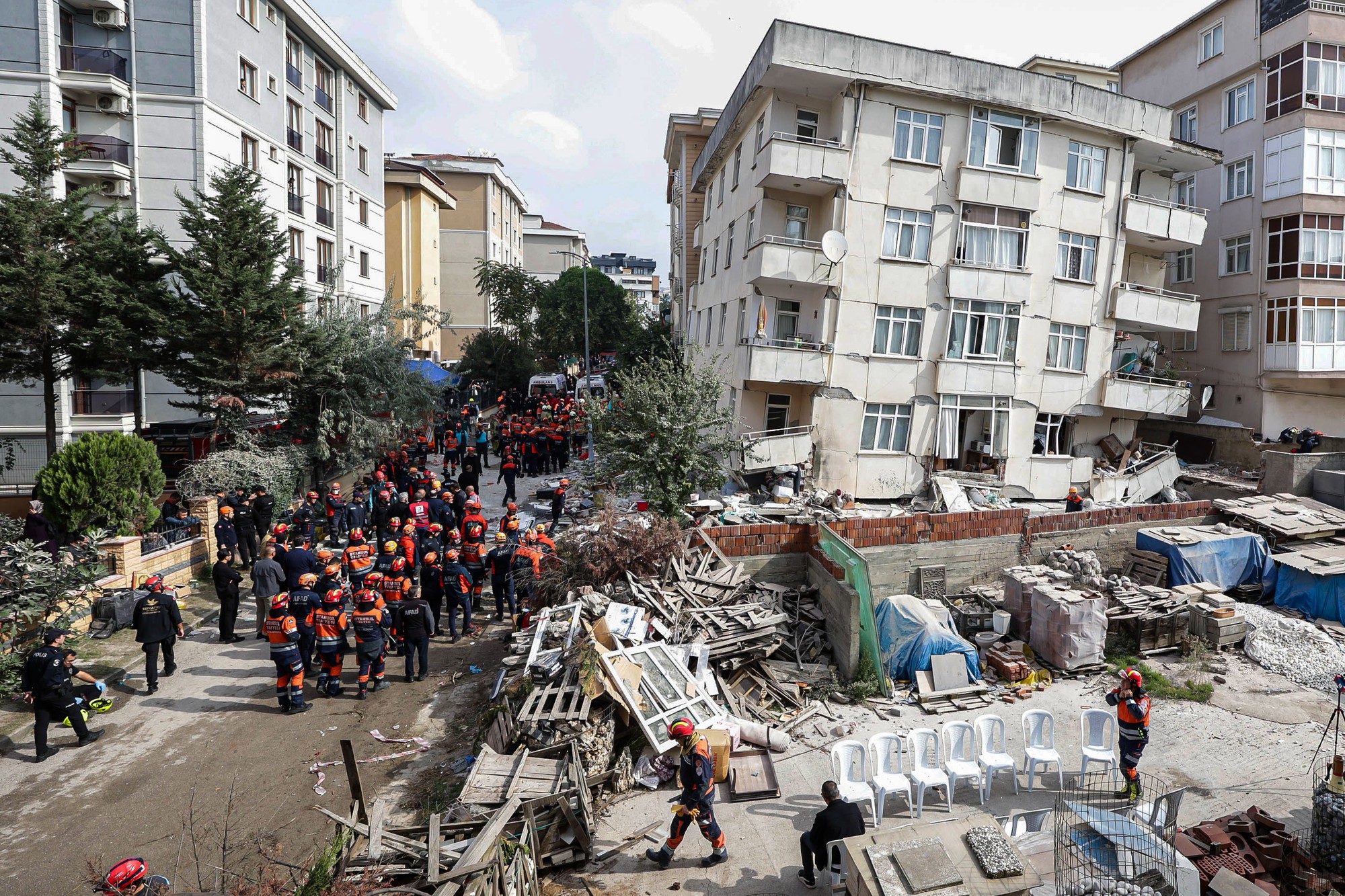 Hasiči a členovia záchranného tímu pracujú vedľa čiastočne zrútenej sedemposchodovej budovy v Istanbule. 
