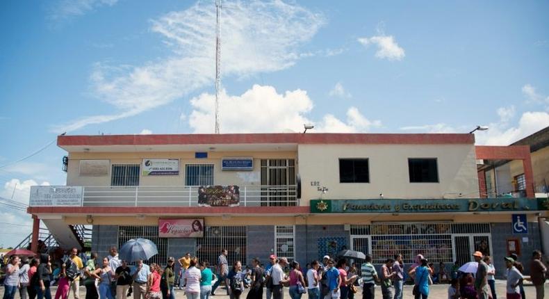 Venezuelans queue outside a supermarket to buy basic food and household items, after massive lootings took place in Ciudad Bolivar, on December 19, 2016