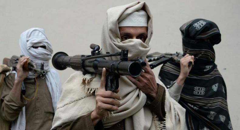 Former Afghan Taliban fighters carry their weapons before handing them over as part of a government peace and reconciliation process, in Jalalabad, in January 2016