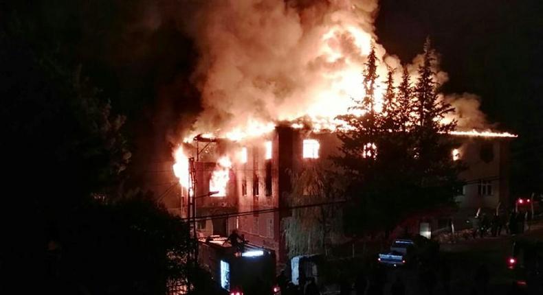 Flames are seen as firefighters try to control a fire at a school in Adana, southern Turkey, on November 29, 2016 that killed 12 people