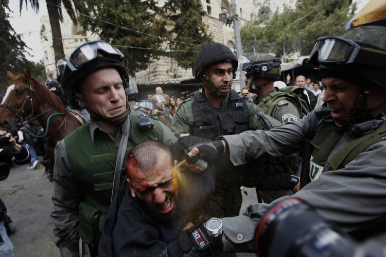 Nagroda specjalna w kategorii General News zdjęcie pojedyncze - fotografia Ammara Awada przedstawiająca izraelskich żołnierzy pryskających Palestyńczyka gazem łzawiącym