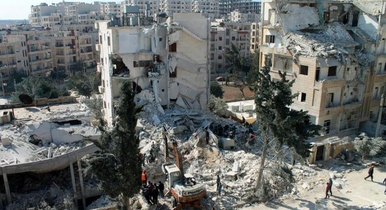 Local men and Civil Defence volunteers search for survivors amid the rubble of a building in the northwestern Syrian city of Idlib on February 7, 2017, following a reported air strike the previous night