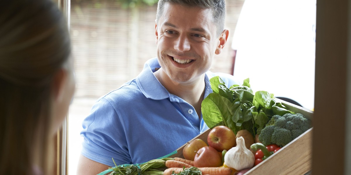 Groceries and packages delivery, covid-19, quarantine and shopping concept. Smiling delivery man in 