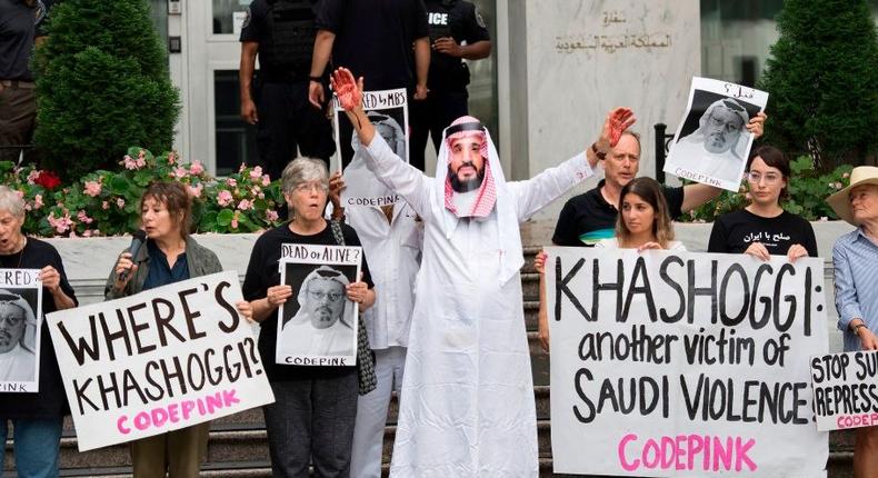 A demonstrator dressed as Saudi Arabian Crown Prince Mohammed bin Salman (C) with blood on his hands protests with others outside the Saudi Embassy in Washington, DC, on October 8, 2018,