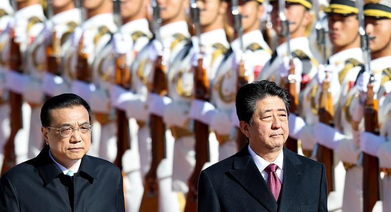 China's Premier Li Keqiang (L) accompanies Japanese Prime Minister Shinzo Abe (R) to view an honour guard during a welcoming ceremony outside the Great Hall of the People on October 26, 2018 in Beijing, China.