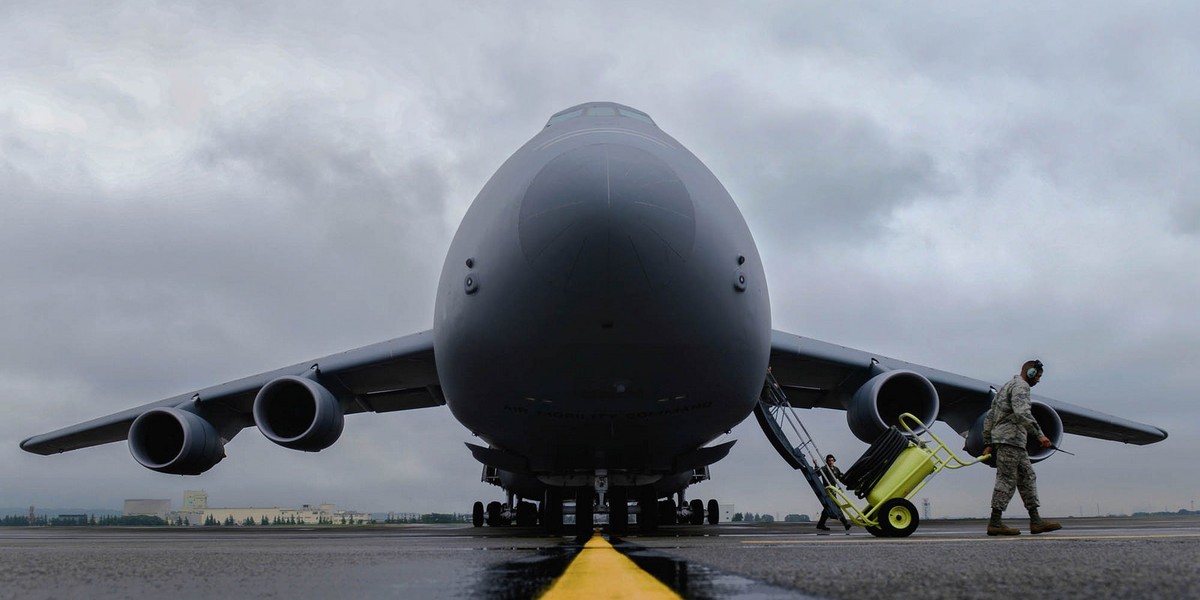 Staff Sgt. Randall Ard, 730th Air Mobility Squadron crew chief, clears the runway for a C-5 Galaxy at Yokota Air Base, Japan, August 31, 2015.