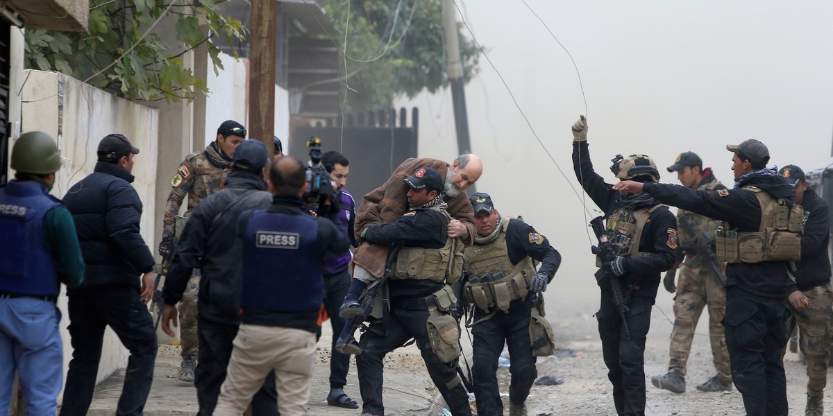 Iraqi Special Operations Forces (ISOF) carry an injured man from clashes during a battle with Islamic State militants in Mosul, Iraq, November 30, 2016