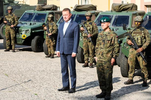 Czerwony Bór (woj. podlaskie), 18.09.2023. Minister obrony narodowej Mariusz Błaszczak (C) oraz dowódca 1. Dywizji Piechoty Legionów gen. bryg. Norbert Iwanowski (2P) podczas wypowiedzi dla mediów po zakończeniu odprawy z kadrą 1. Dywizji Piechoty Legionów im. marszałka Józefa Piłsudskiego w Czerwonym Borze.