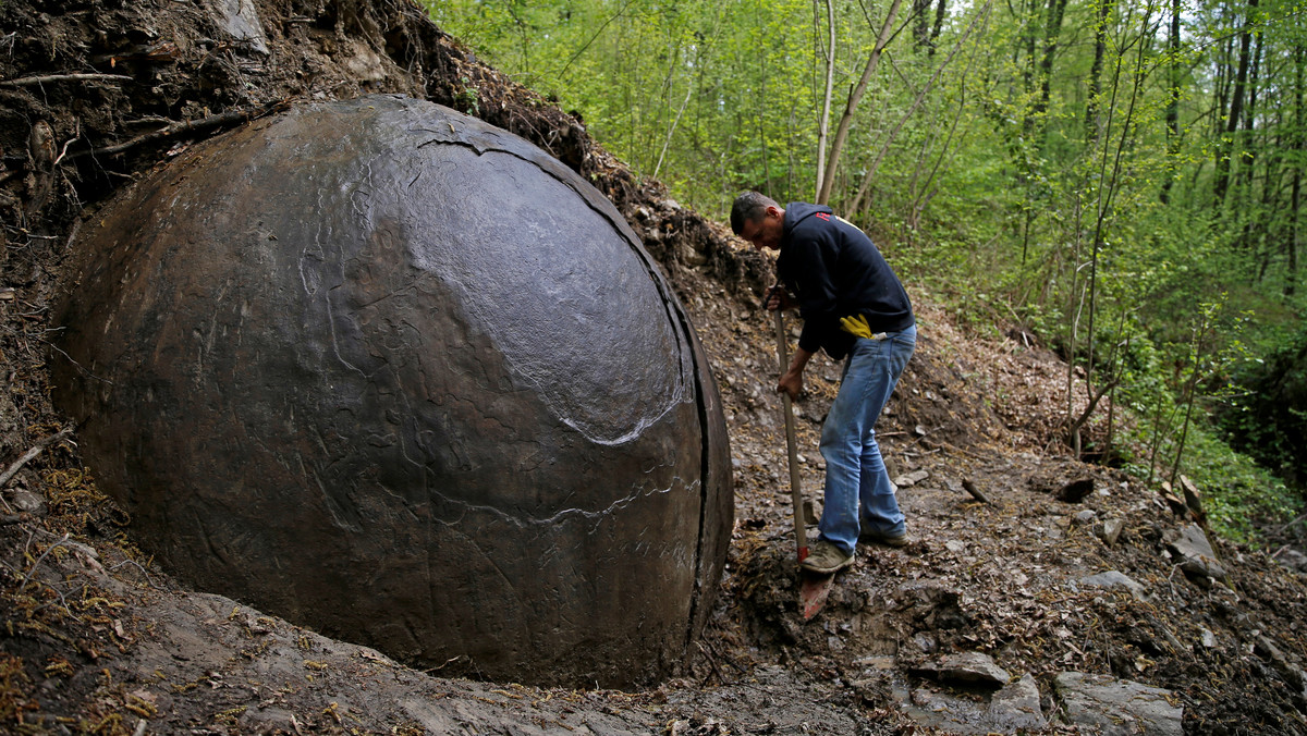 Suad Keserovic cleans a stone ball in Podubravlje village near Zavidovici