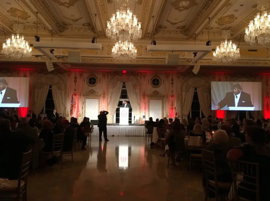 Prelegent przedstawia ówczesnego gubernatora Florydy Ricka Scotta w sali balowej Donalda J. Trumpa w Mar-a-Lago.