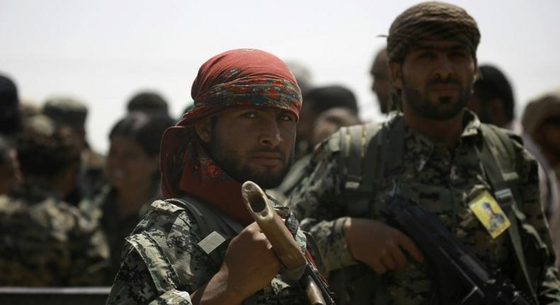 Members of the US-backed Syrian Democratic Forces (SDF) stand in the village of Hazima on the northern outskirts of the Islamic State (IS) group's Syrian bastion of Raqa on June 6, 2017