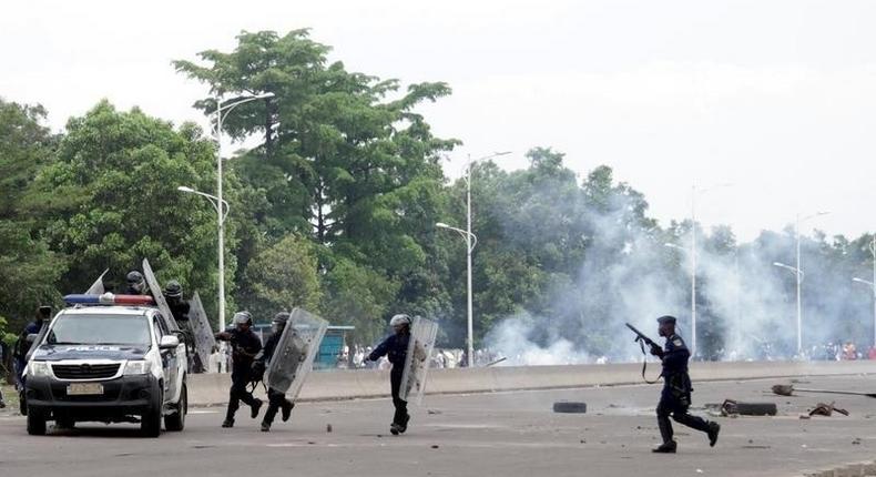 Congolese policemen run to their vehicle during a clash with opposition activists participating in a march to press President Joseph Kabila to step down in the Democratic Republic of Congo's capital Kinshasa, September 19, 2016. 