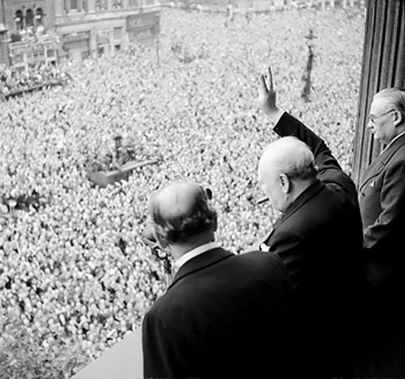 Winston Churchill pozdrawia tłumy z jednego z budynków rządowych na ulicy Whitehall