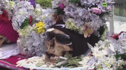 Przystrojone w kwiaty, czapki, z papierosem. Dzień Czaszki w Boliwii. WIDEO
