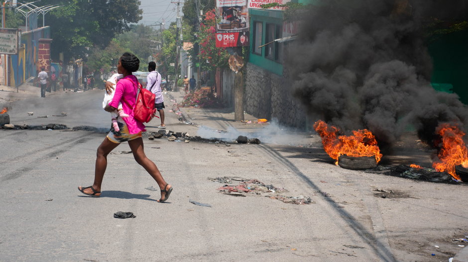 Kobieta ucieka przed strzałami w stolicy Port au-Prince, Haiti, 20 marca 2024 r.