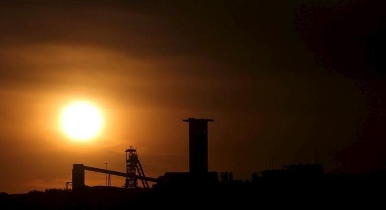 The sun sets behind a shaft outside the mining town of Carletonville, west of Johannesburg, July 7 2015. REUTERS/Siphiwe Sibeko