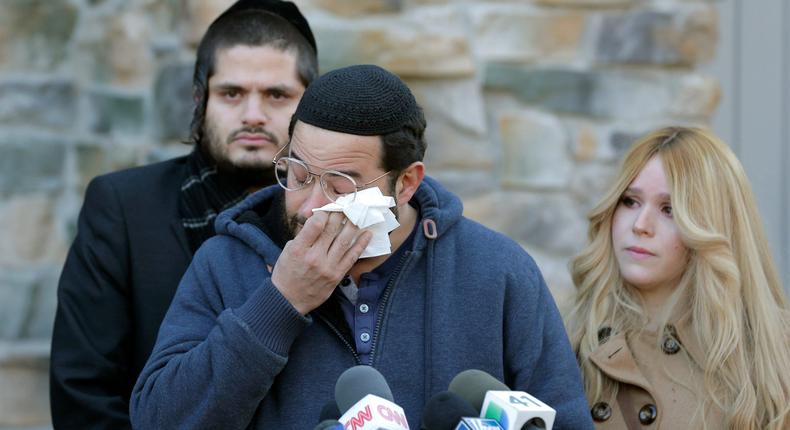 Surrounded primarily by family, David Neumann, center, wipes his eyes as he speaks to reporters in New City, N.Y., Thursday, Jan. 2, 2020, about his father, Josef Neumann, who was critically injured in an attack on a Hanukkah celebration.