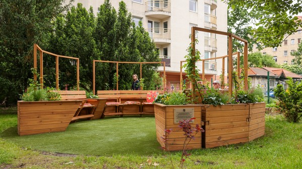 Piekna zielona pergola z miejscami do siedzenia to jeden z elementów projketu