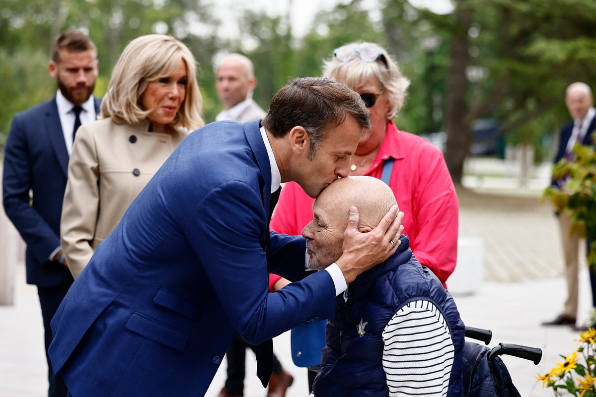 Prezydent Francji Emmanuel Macron wraz z żoną Brigitte Macron przed lokalem wyborczym w Le Touquet-Paris-Plage w północnej Francji. Prezydent całuje obywatela z niepełnosprawnością, który także przybył zagłosować