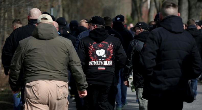 The silent, mostly male crowd lined the road leading to a cemetery for the funeral of Thomas Haller, the co-founder of a group called HooNaRa (Hooligans-Nazis-Racists)