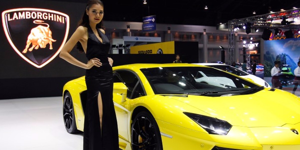 A model poses beside a Lamborghini Aventador LP700-4 during a media presentation at the 37th Bangkok International Motor Show in Bangkok