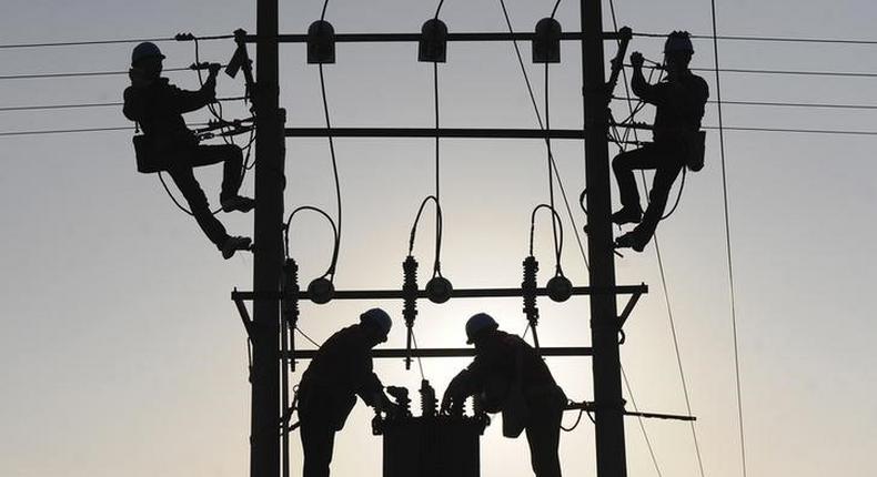 Labourers work on an electricity pylon in Huangni village of Chuzhou, Anhui province March 17, 2014. REUTERS/China Daily