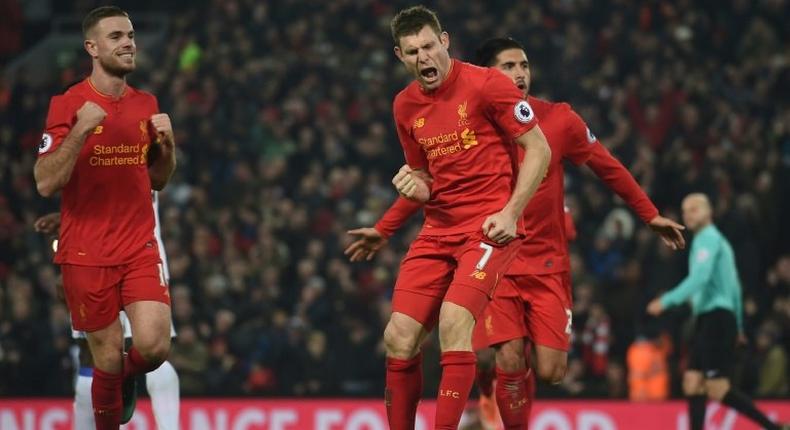 Liverpool's midfielder James Milner (C) celebrates after scoring their second goal from the penalty spot with midfielder Jordan Henderson (L) and midfielder Emre Can (R) during the Premier League football match against Sunderland November 26, 2016