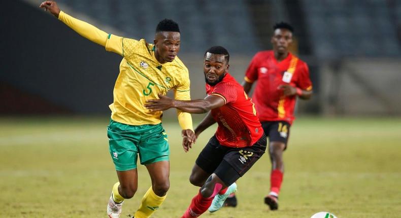 South African Sibusiso Mabiliso (L) and Ugandan Abdu Lumala seek possession during a friendly international in Soweto on Thursday. Creator: PHILL MAGAKOE