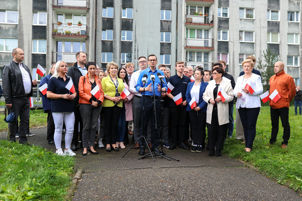 Premier Mateusz Morawiecki (C) podczas wizyty na osiedlu z wielkiej płyty w Katowicach