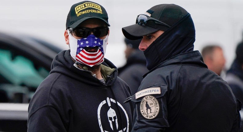 People wearing hats and patches indicating they are part of Oath Keepers attend a rally at Freedom Plaza Tuesday, Jan. 5, 2021, in Washington, in support of President Donald Trump.