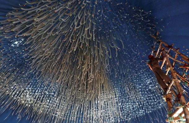 An electrician hangs decorative lights at a pandal for the upcoming Hindi festival of Durga Puja in 