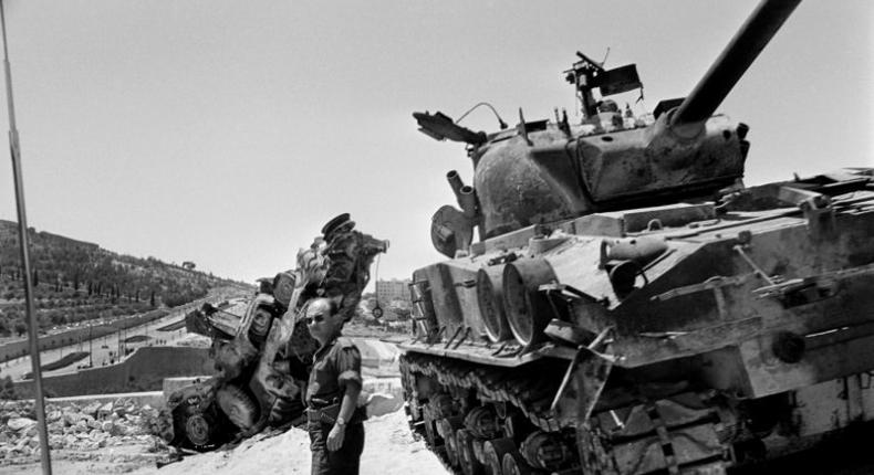 An Israeli soldier checks a destroyed tank on the road between Bethleem and Jerusalem in June 1967 during the Six-Day War