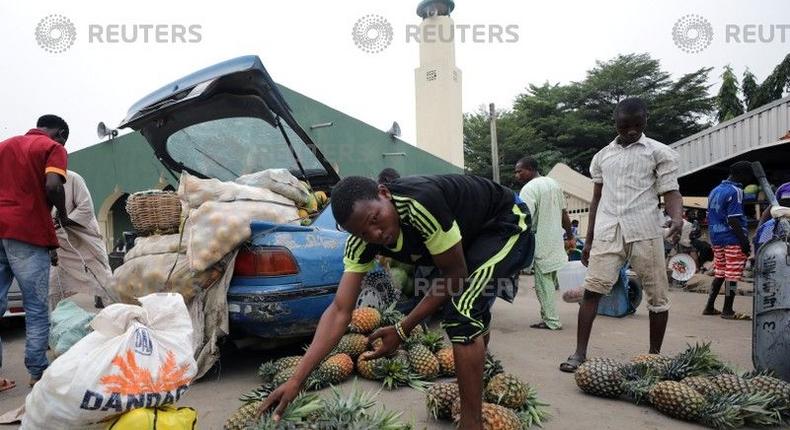 A man arranges pineapples at the Wuse market in Abuja, Nigeria May 15, 2018. 