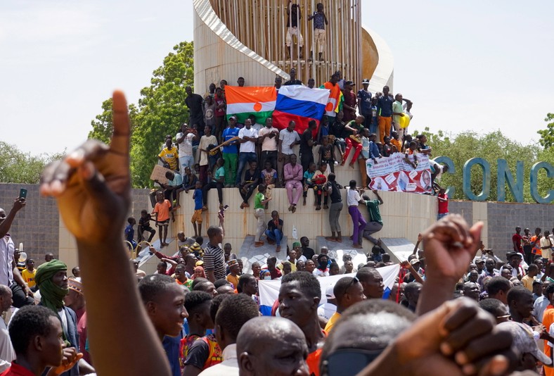 Demonstranci wywieszają flagi Rosji i Nigru przed budynkiem Zgromadzenia Narodowego podczas protestu w Niamey, Niger, 30 lipca 2023 r.