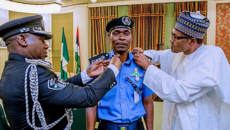 Mohammad Adamu (middle) decorated by Idris Ibrahim (left) and President Muhammadu Buhari (right) as the new Inspector-General of Police [Twitter/@NGRPresident]