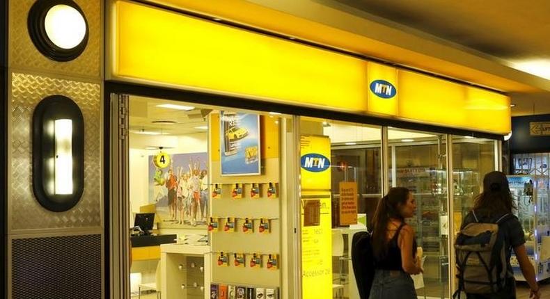 People walk past an outlet of South Africa's MTN Group in downtown Cape Town, November 10, 2015.  REUTERS/Mike Hutchings