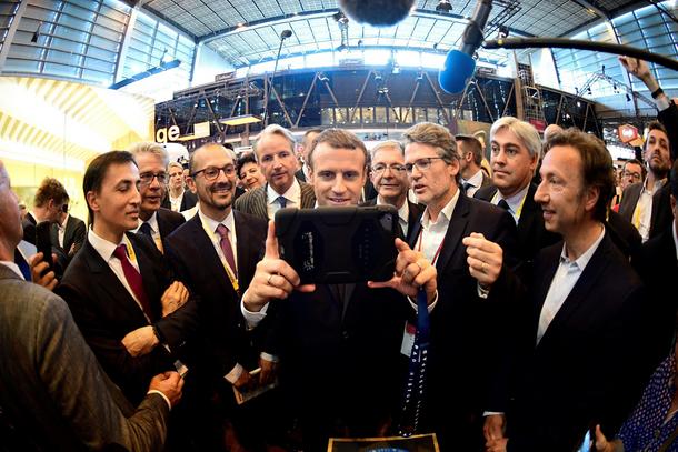 French President Emmanuel Macron holds a device at the Viva Technology event dedicated to start-ups