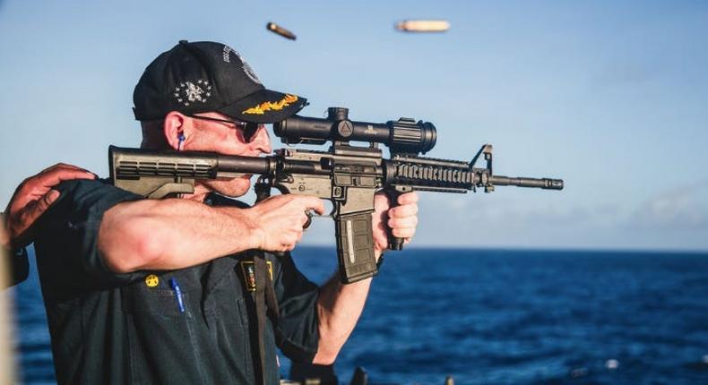 The now-deleted image of commander Cameron Yaste firing a rifle with a back-to-front scope and the lens cap still attached.US Navy/Web Archive