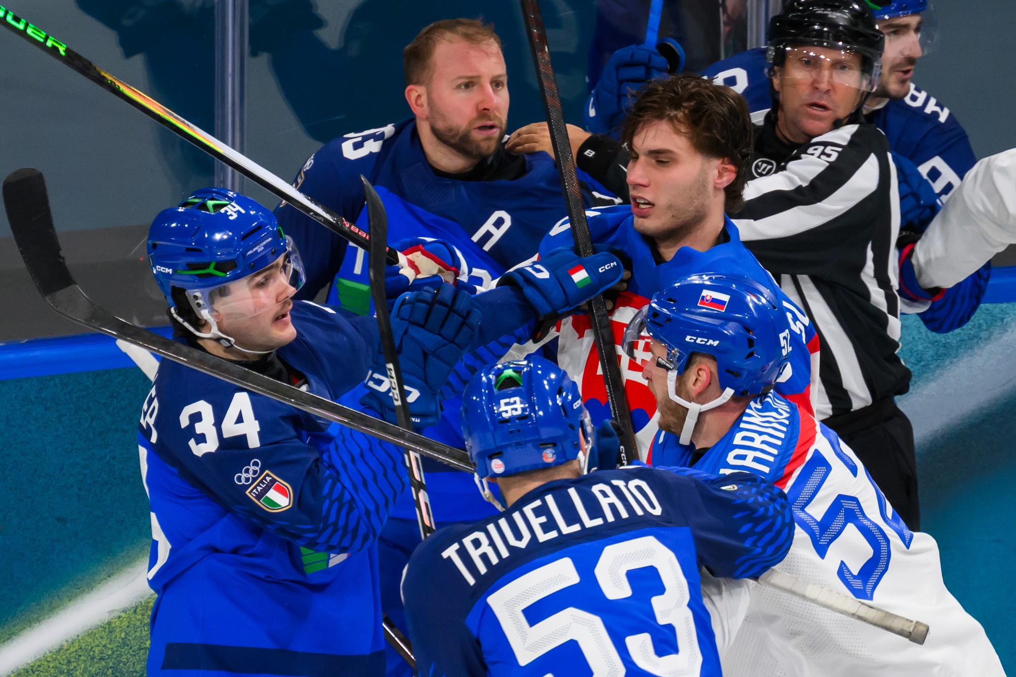 Zľava Tommy Purdeller (Taliansko) a sprava Juraj Slafkovský (Slovensko) a Martin Marinčin (Slovensko) počas bitky. 