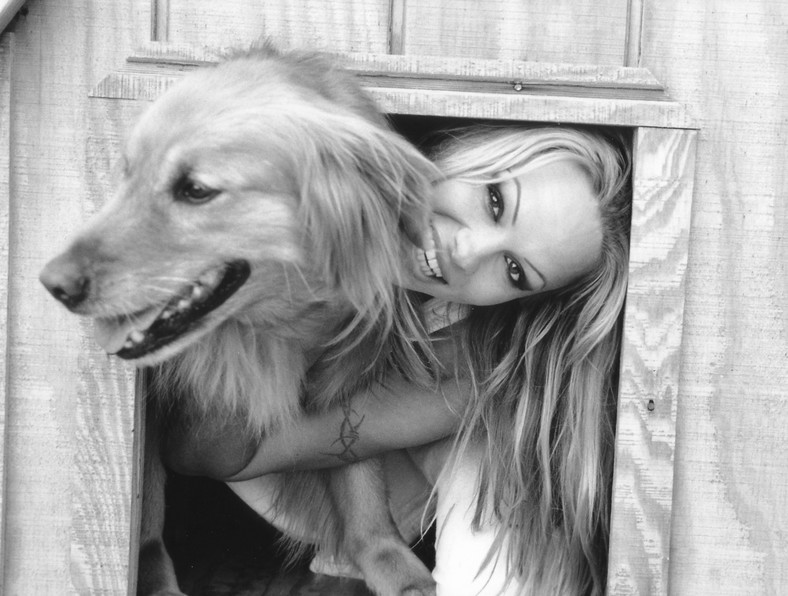 Pamela Anderson przytula swojego golden retrievera na podwórku swojego domu [maj 2002]