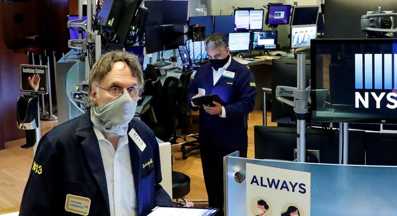 Traders wearing masks work, on the first day of in person trading since the closure during the outbreak of the coronavirus disease (COVID-19) on the floor at the New York Stock Exchange (NYSE) in New York, U.S., May 26, 2020. REUTERS/Brendan McDermid