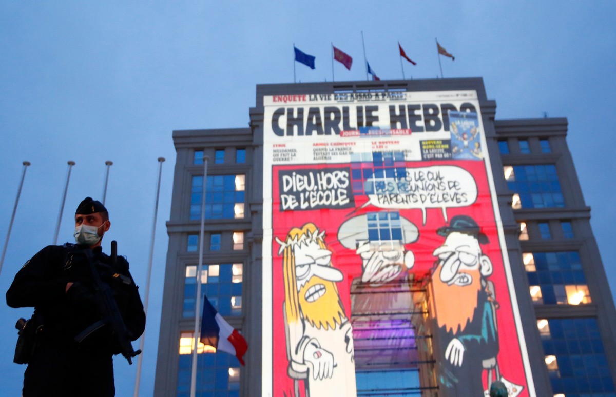 Francuski oficer przed rysunkiem z pisma "Charlie Hebdo"