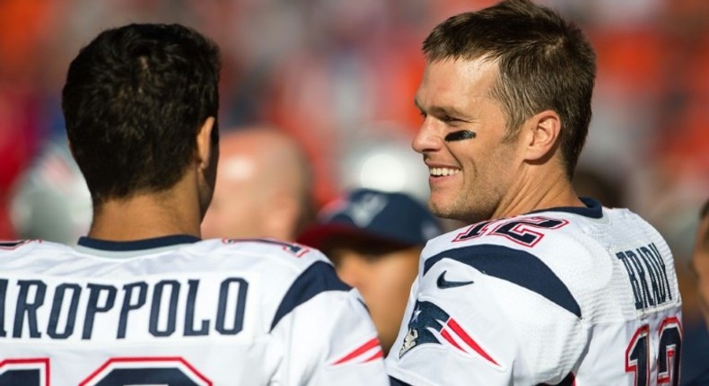 Quarterbacks Jimmy Garoppolo and Tom Brady of the New England Patriots talk on the sidelines against the Cleveland Browns, in Cleveland, Ohio, on October 9, 2016