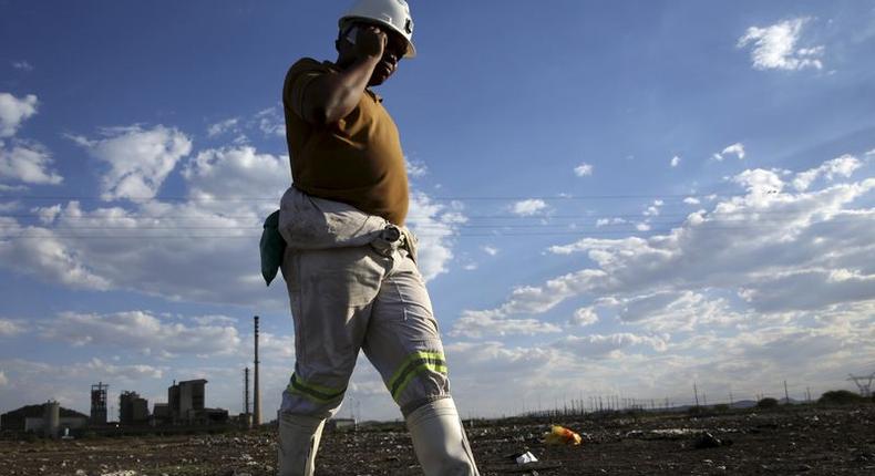 A mine worker speaks on his mobile phone as he returns from the Lonmin mine at the end of his shift, outside Rustenburg, northwest of Johannesburg, South Africa November 10, 2015. REUTERS/Siphiwe Sibeko