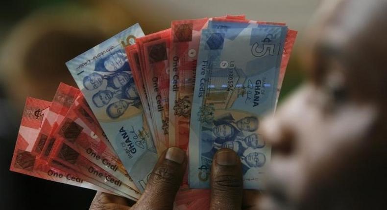 A man holds Ghana's cedi notes in Accra