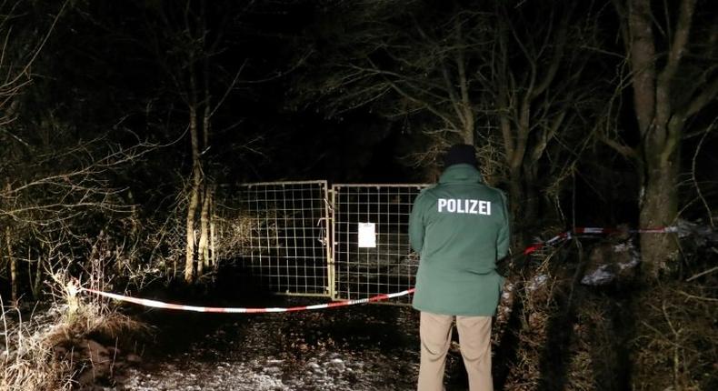 A policeman stands in front of an entrance leading to the site where six teenagers were found dead after holding a party in a garden near Arnstein, southern Germany, on January 29, 2017