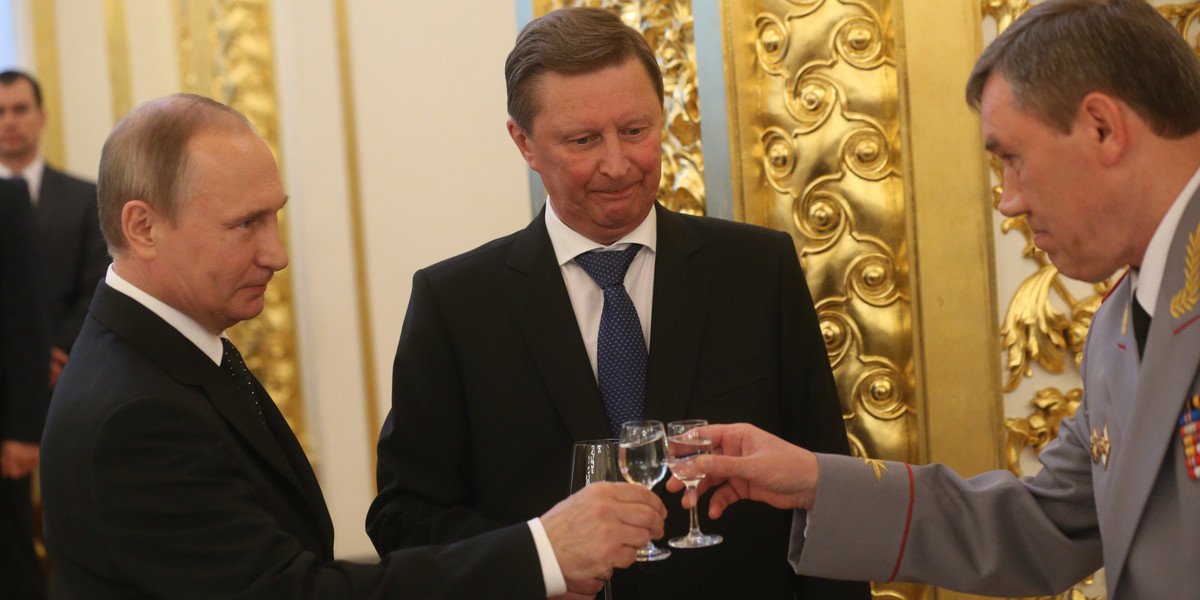 Prezydent Rosji Władimir Putin (po lewej) wznosi toast kieliszkiem wódki z wiceministrem obrony Walerym Gierasimowem (po prawej) i szefem sztabu administracji prezydenta Siergiejem Iwanowem (w środku)