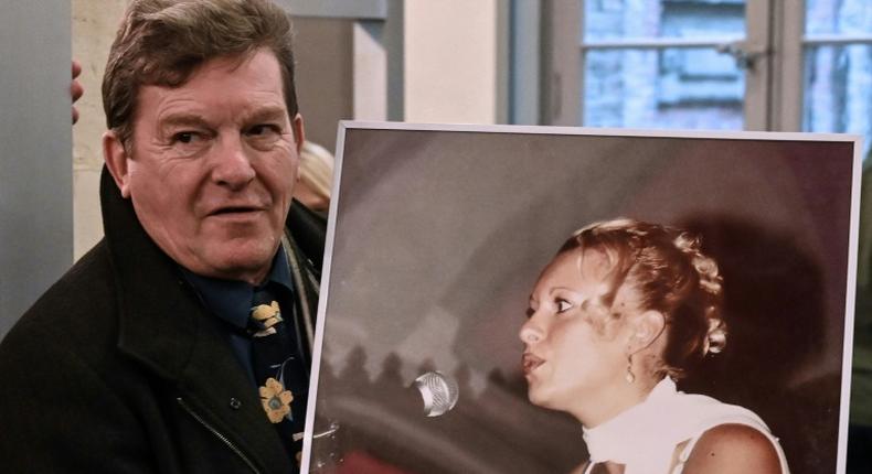 Jacky Kulik holds a portrait of his daughter Elodie who was kidnapped, raped, strangled and her corpse then burned in northern France in January 2002